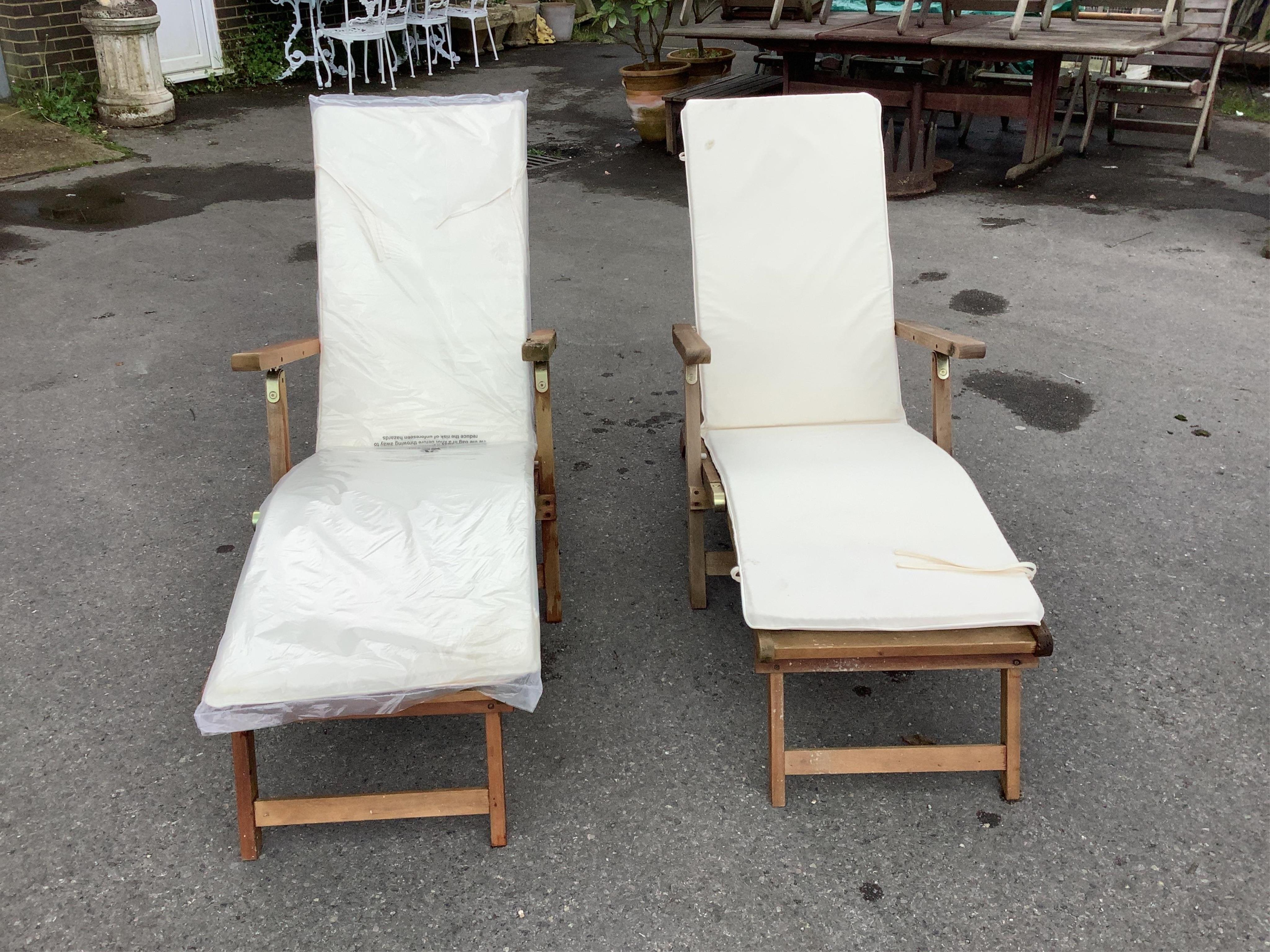 A pair of John Lewis brass mounted folding teak steamer garden chairs with seat cushions